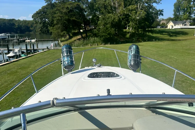 Slide: The Image of 2006 Sea Ray 260 Sundancer boat on grassy area near waterfront dock. - 61