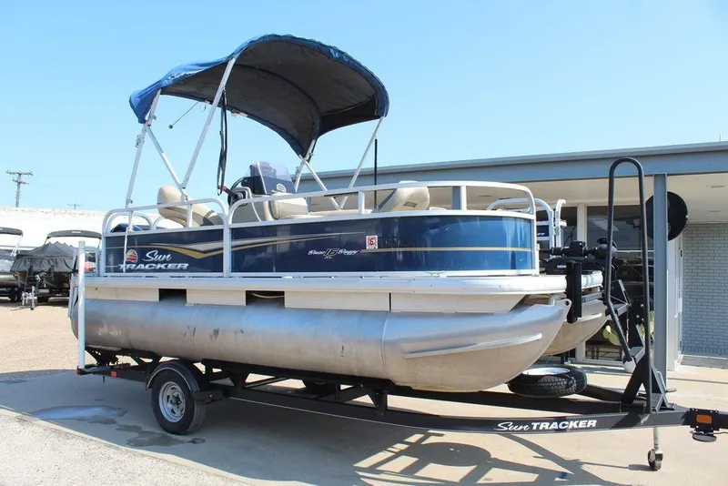 The Image of 2020 Sun Tracker BASS BUGGY® 16 DLX pontoon boat on trailer, blue canopy. - 1