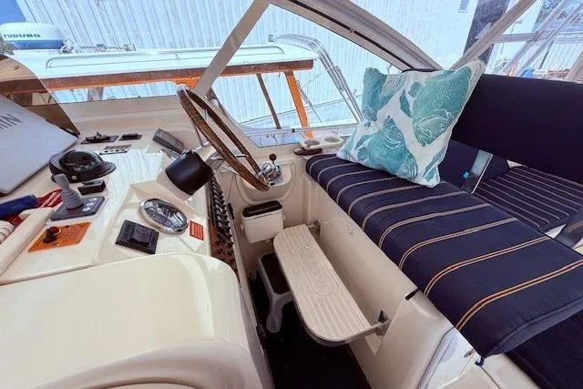 Slide: The Image of 2004 Mainship Pilot 34 helm with striped seating and nautical decor. - 10