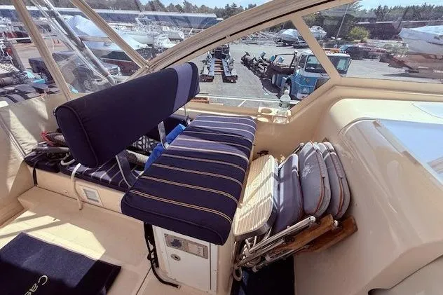 Slide: The Image of 2004 Mainship Pilot 34 cockpit with striped seating and marina view. - 12