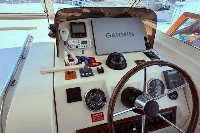 Slide: The Image of 2004 Mainship Pilot 34 helm with Garmin navigation and classic steering wheel. - 13