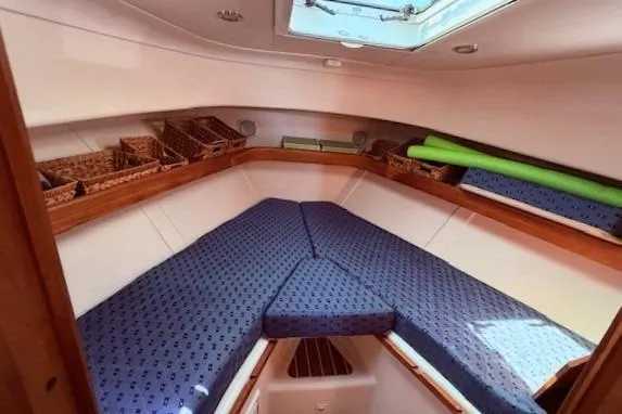 Slide: The Image of 2004 Mainship Pilot 34 cabin interior with blue cushions and storage baskets. - 18
