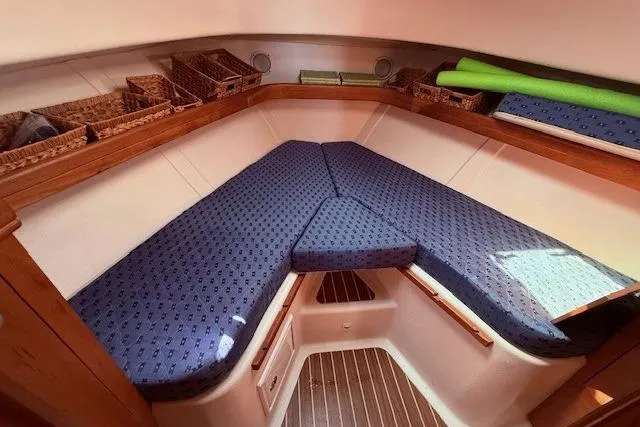 Slide: The Image of 2004 Mainship Pilot 34 cabin interior with blue cushions and wooden accents. - 19