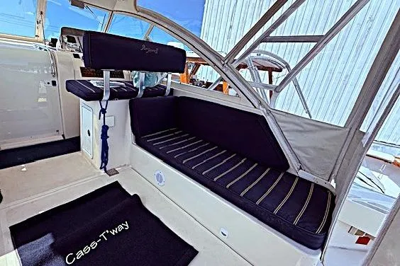 Slide: The Image of 2004 Mainship Pilot 34 interior with navy seating and striped cushions. - 8