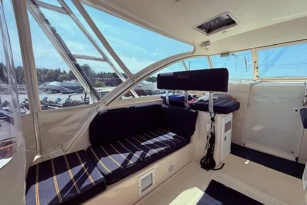 Slide: The Image of 2004 Mainship Pilot 34 interior with navy seating and large windows. - 9