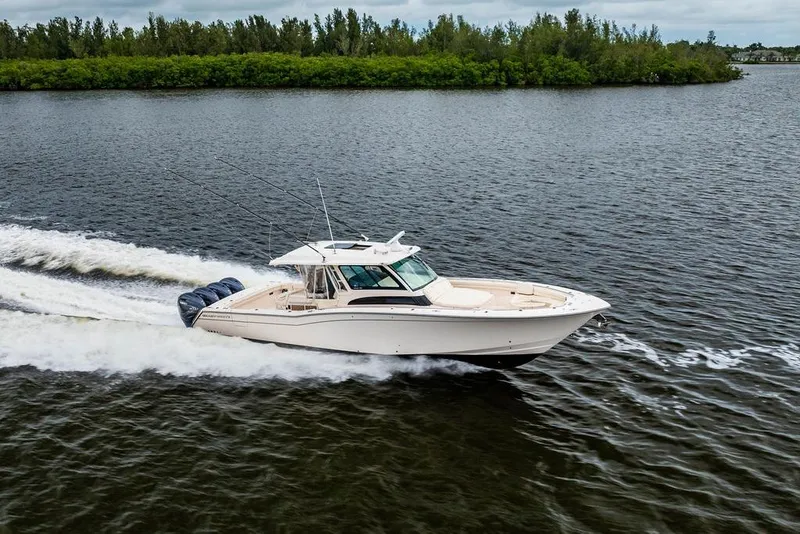The Image of 2022 Grady-White Canyon 456 boat cruising on a scenic waterway. - 0