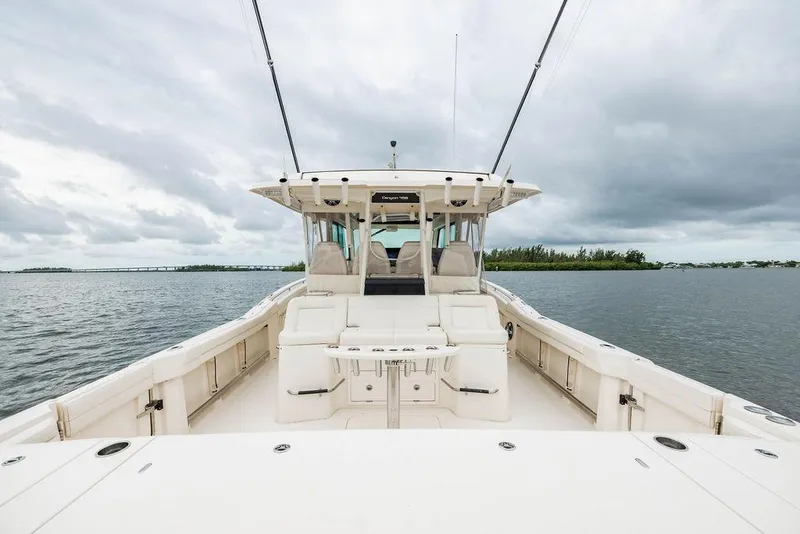 Slide: The Image of 2022 Grady-White Canyon 456 boat on calm water under cloudy sky. - 13