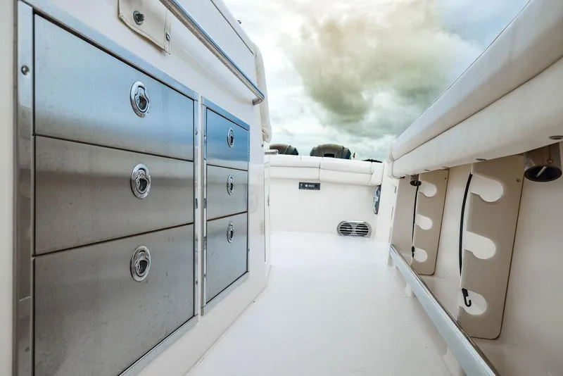 Slide: The Image of 2022 Grady-White Canyon 456 boat interior with storage compartments and rod holders. - 18