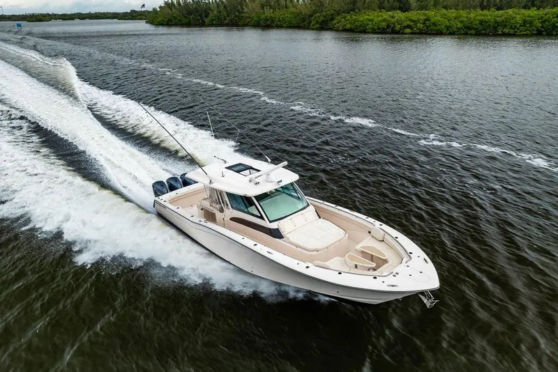 Slide: The Image of 2022 Grady-White Canyon 456 cruising on a scenic waterway, showcasing sleek design and power. - 2
