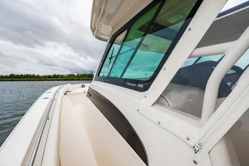 Slide: The Image of 2022 Grady-White Canyon 456 boat on water, showcasing sleek design and windows. - 27