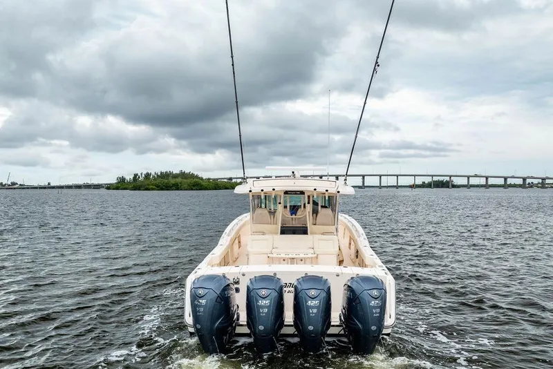 Slide: The Image of 2022 Grady-White Canyon 456 boat with four engines on open water under cloudy sky. - 3