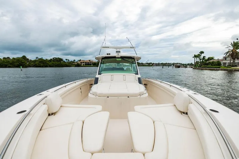 Slide: The Image of 2022 Grady-White Canyon 456 boat on calm water, featuring spacious seating and modern design. - 31