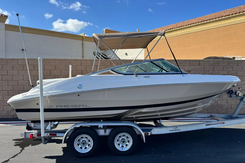 The Image of 2016 Regal 2000 ES boat on trailer, parked outdoors under clear sky. - 0