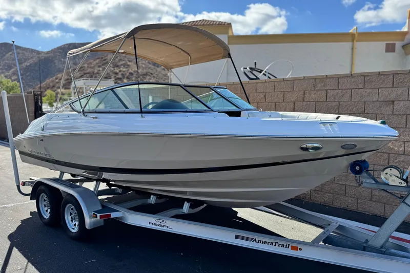 Slide: The Image of 2016 Regal 2000 ES boat on trailer, parked outdoors under a clear sky. - 1