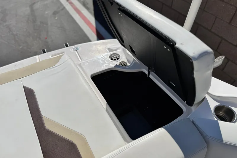 Slide: The Image of Open storage compartment on a 2016 Regal 2000 ES boat, featuring white and beige seating. - 17