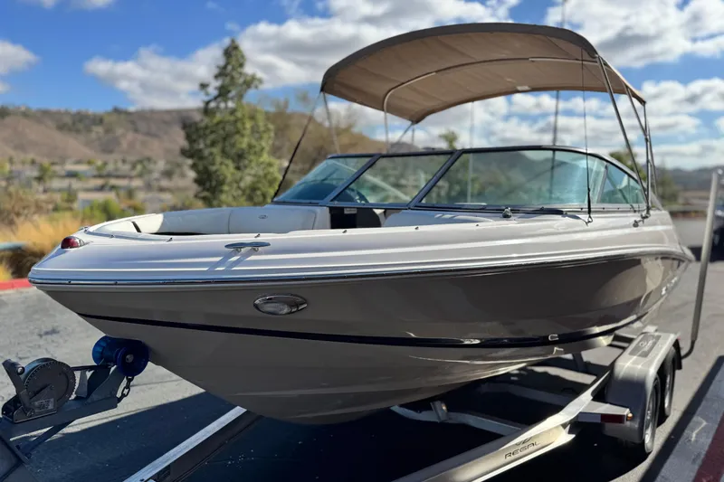 Slide: The Image of 2016 Regal 2000 ES boat on trailer, parked outdoors under a blue sky. - 3