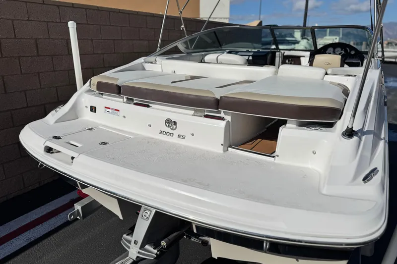 Slide: The Image of 2016 Regal 2000 ES boat with white and brown seating, parked outdoors. - 6