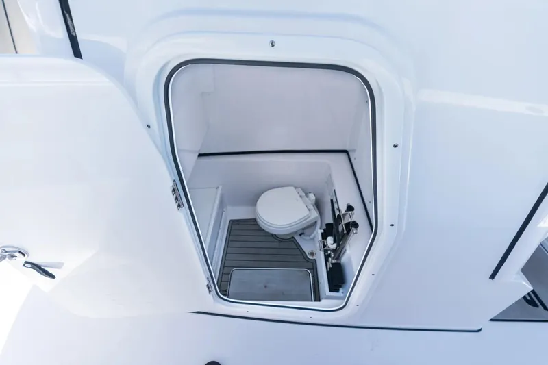 Slide: The Image of 2026 Sportsman Open 282 Center Console boat interior with compact marine toilet. - 10
