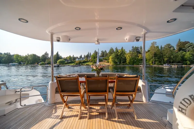 Slide: The Image of Luxurious 2008 Hatteras 72 Motor Yacht deck with scenic lake view and elegant seating. - 18