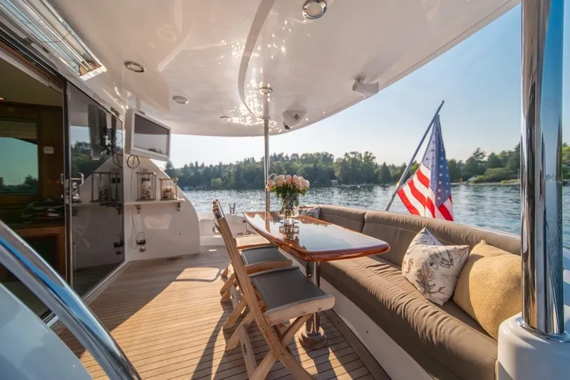 Slide: The Image of Luxurious 2008 Hatteras 72 Motor Yacht deck with elegant seating and American flag. - 20