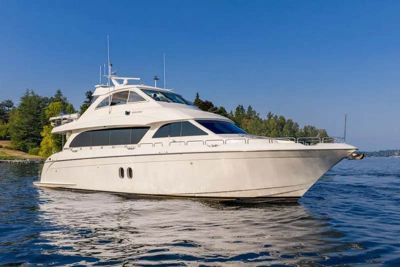 Slide: The Image of 2008 Hatteras 72 Motor Yacht cruising on a serene lake with lush greenery. - 4