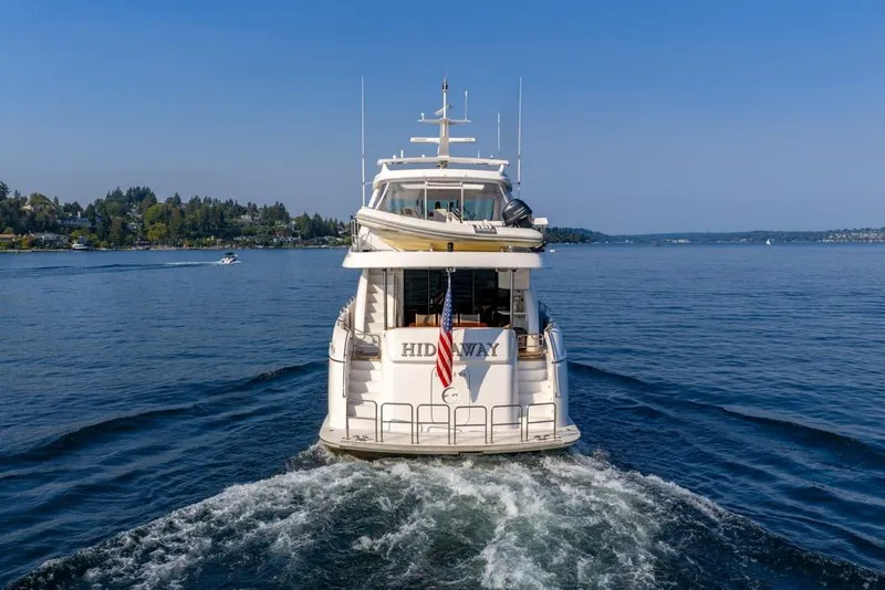 Slide: The Image of 2008 Hatteras 72 Motor Yacht cruising on a serene lake with clear blue skies. - 5