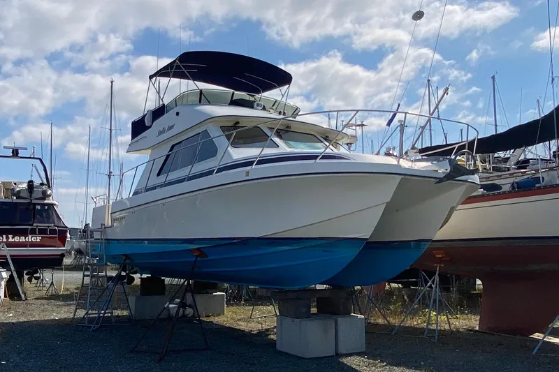 The Image of A 2003 Zeta 36 boat on dry dock, surrounded by other vessels under a cloudy sky. - 0