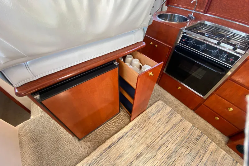 Slide: The Image of Kitchen area in a 2003 Zeta 36 boat with stove, sink, and storage. - 16