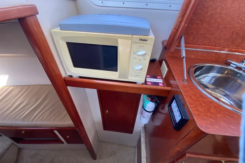 Slide: The Image of Compact kitchen area in a 2003 Zeta 36 boat with microwave and sink. - 17