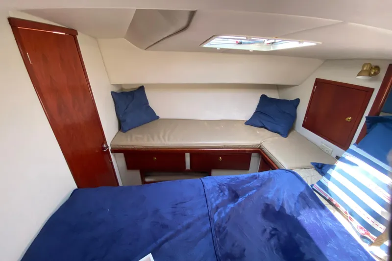 Slide: The Image of Cozy cabin interior of 2003 Zeta 36 boat with blue bedding and wooden accents. - 22