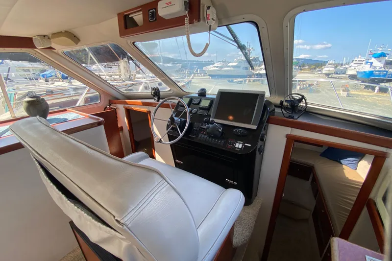 Slide: The Image of Interior of 2003 Zeta 36 boat with steering wheel, navigation equipment, and dock view. - 28