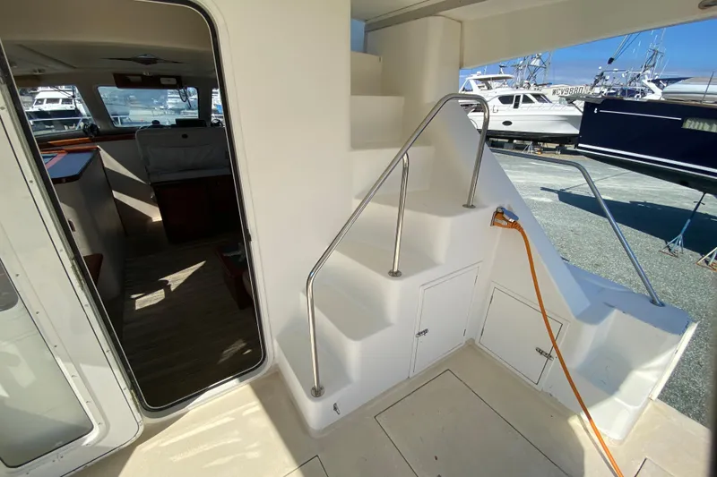 Slide: The Image of Interior view of 2003 Zeta 36 boat with stairs and marina background. - 45