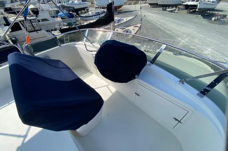 Slide: The Image of Covered seating area on a 2003 Zeta 36 boat, docked among other vessels. - 48