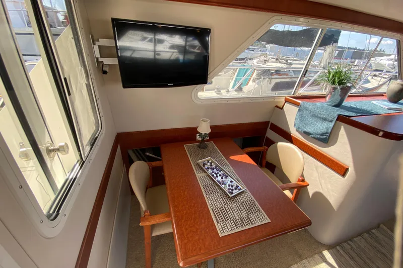 Slide: The Image of Cozy interior of 2003 Zeta 36 yacht with dining area and window view. - 9