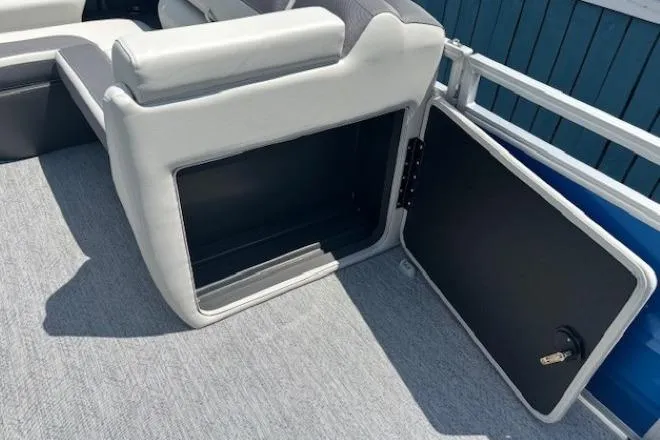 Slide: The Image of 2026 Sun Tracker Fishin' Barge 20 DLX storage compartment with open door and seating. - 15