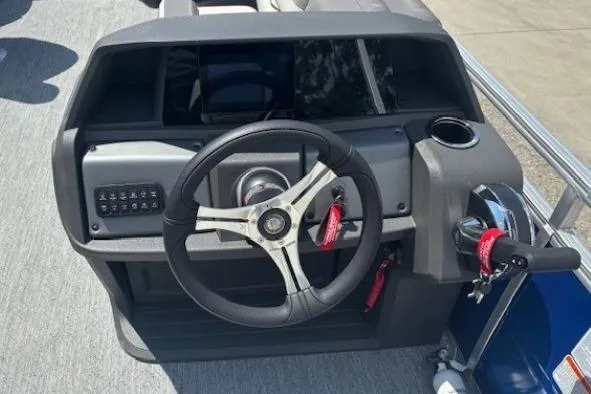 Slide: The Image of 2026 Sun Tracker Fishin' Barge 20 DLX steering console with modern controls and cup holder. - 16