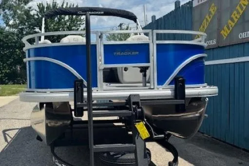Slide: The Image of 2026 Sun Tracker Fishin' Barge 20 DLX pontoon boat on trailer, blue exterior. - 2