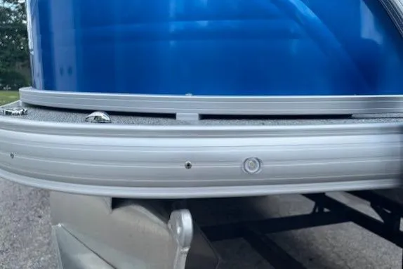 Slide: The Image of 2026 Sun Tracker Fishin' Barge 20 DLX pontoon boat, close-up of blue exterior and railing. - 3