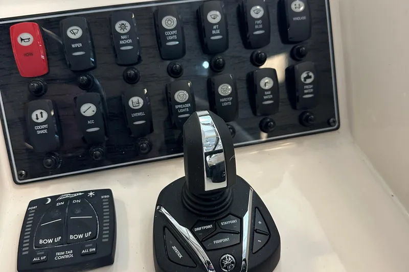 Slide: The Image of Control panel of 2025 Grady-White Freedom 275 boat with switches and joystick. - 10