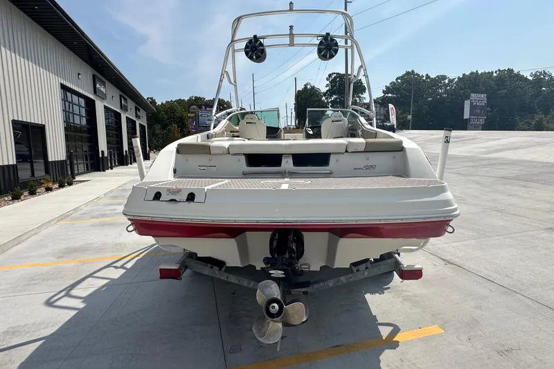 Slide: The Image of 2007 Sea Ray 230 Select boat on trailer, rear view, parked outside a building. - 2