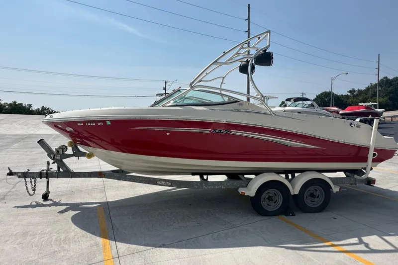 Slide: The Image of 2007 Sea Ray 230 Select boat on trailer, red and white design, parked outdoors. - 4