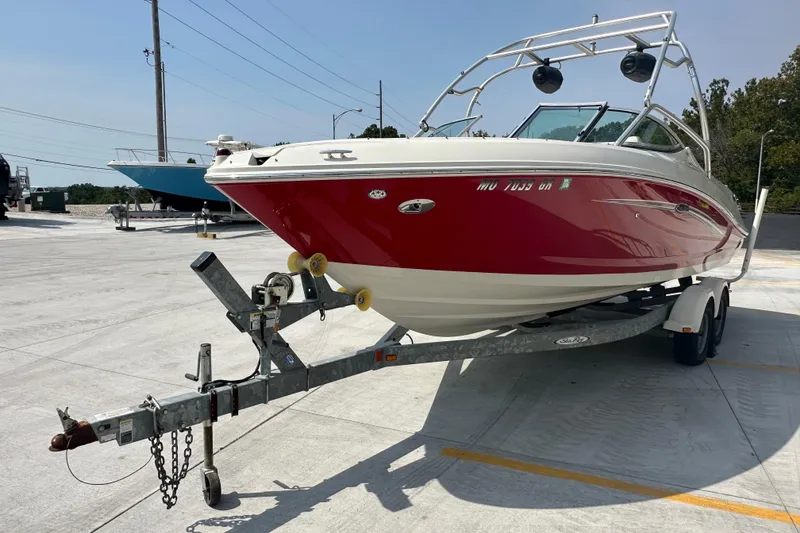 Slide: The Image of 2007 Sea Ray 230 Select boat on trailer, red and white design, parked outdoors. - 6