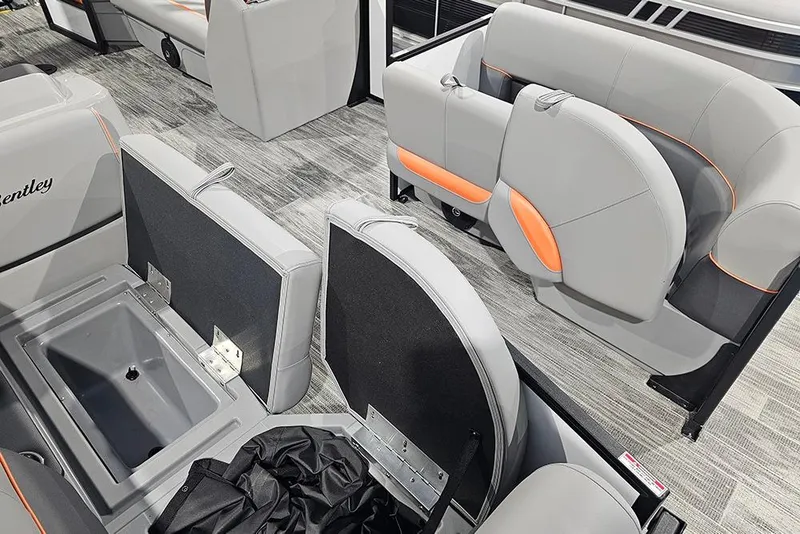 Slide: The Image of 2026 Bentley Pontoons Bolt interior with gray and orange seating, showcasing storage compartments. - 18