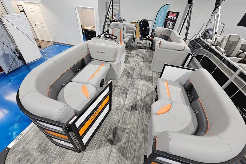 Slide: The Image of 2026 Bentley Pontoons Bolt interior with gray and orange seating, showroom display. - 6