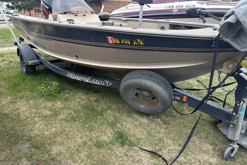 Slide: The Image of 2001 Alumacraft Tournament Pro 185 CS boat on ShoreLand'r trailer, parked on grass. - 1