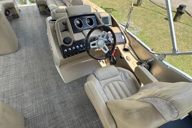 Slide: The Image of 2016 Bennington 2575 RCW boat interior with beige seating and control panel. - 10