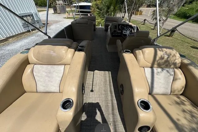 Slide: The Image of 2016 Bennington 2575 RCW pontoon boat interior with beige seating and steering console. - 14
