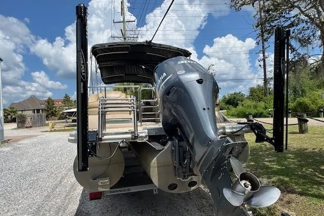 Slide: The Image of 2016 Bennington 2575 RCW pontoon boat with Yamaha outboard motor, parked on gravel driveway. - 5
