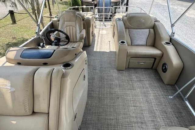 Slide: The Image of 2016 Bennington 2575 RCW pontoon boat interior with beige seating and steering console. - 7