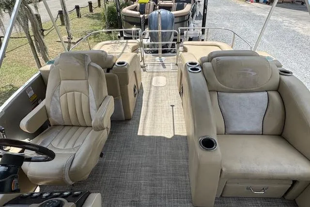 Slide: The Image of 2016 Bennington 2575 RCW pontoon boat interior with beige seating and steering console. - 8